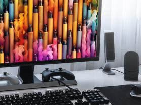 A computer monitor displays a rainbow array of e-cigarettes on its screen