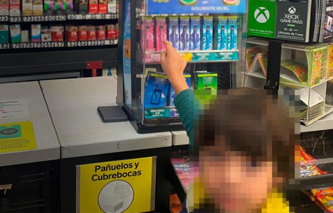 A child with their face blurred reaches their outstretched arm towards a countertop tobacco product display at a retailer in Mexico